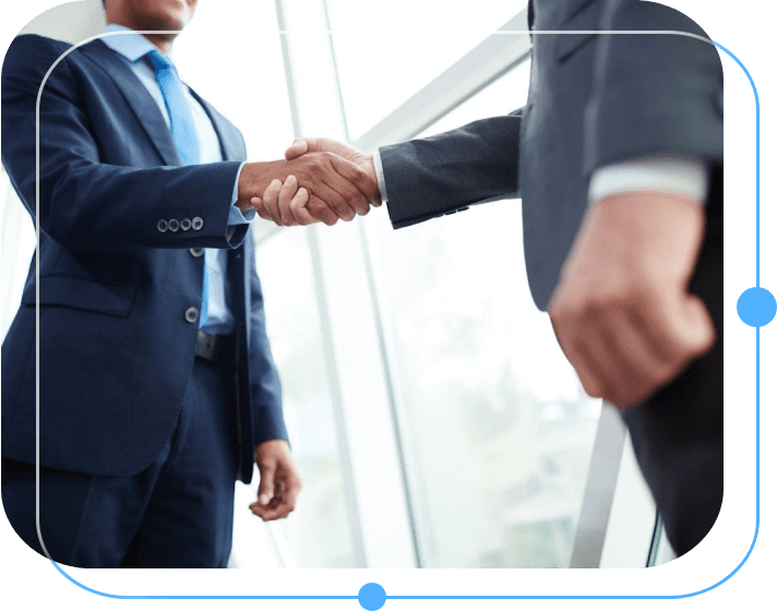 Two men in suits shaking hands while standing next to each other.