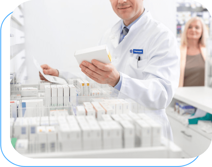 A man in white lab coat holding papers near shelves of medicine.